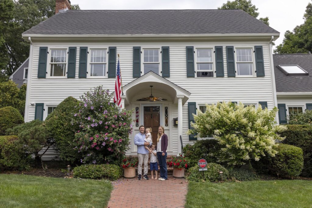 suburban house with a family and a wayne alarm sign